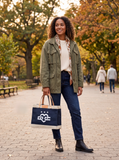 Woman carrying the Unofficial DC × Apolis Petite Market Bag in Navy with the DC Love emblem on the front panel